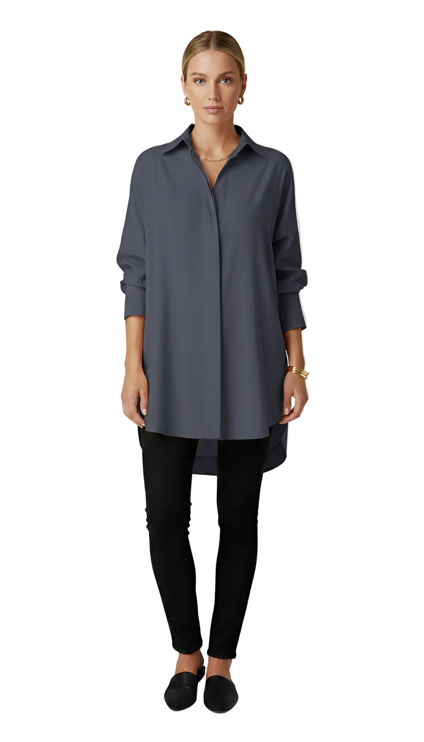 Woman wearing a long dark gray shirt and black pants on a light gray background