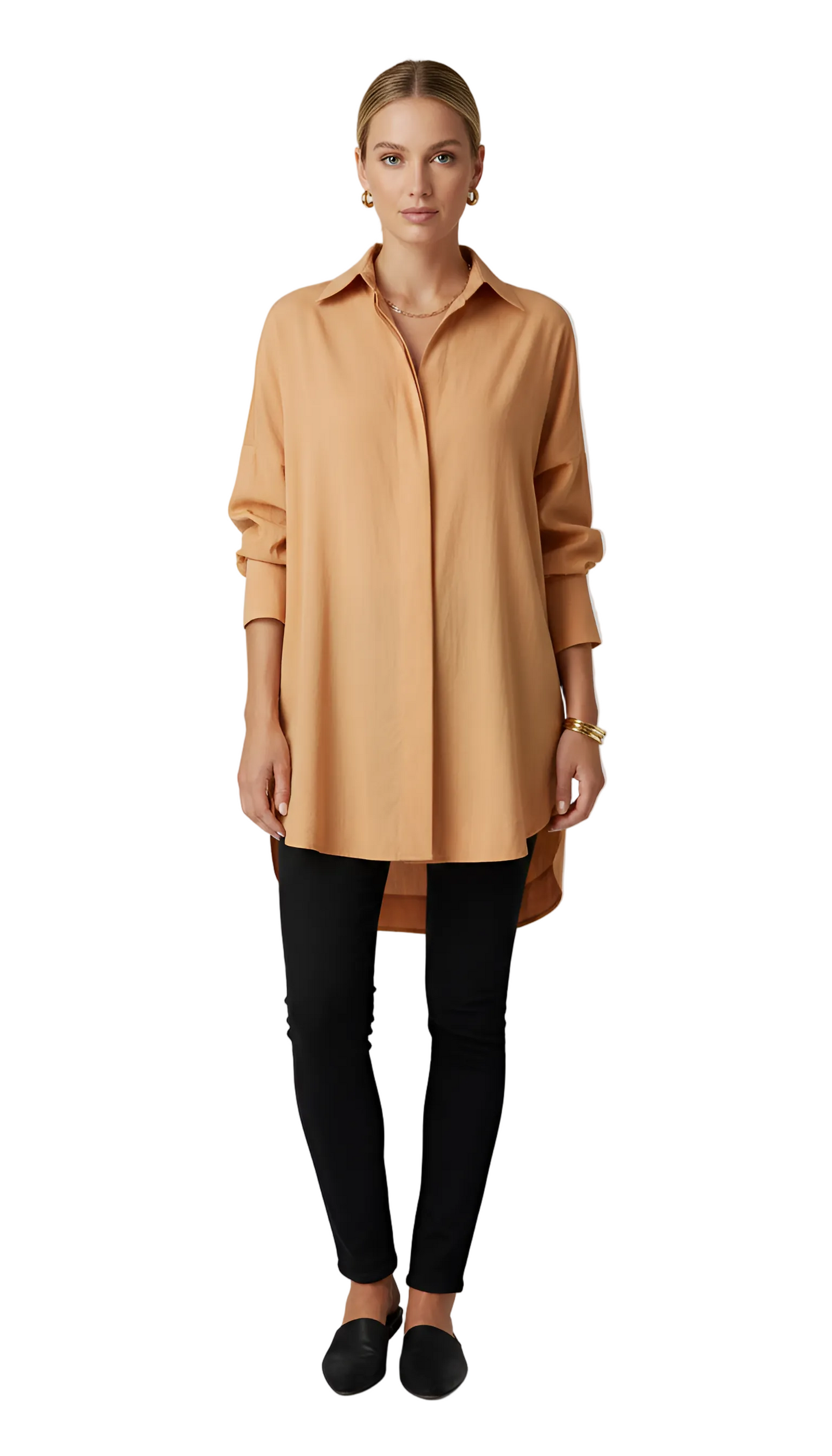 Woman wearing a tan long-sleeve shirt and black pants on a white background